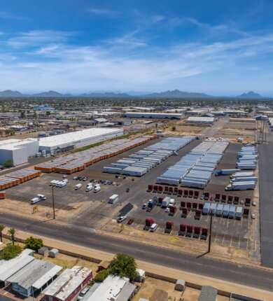Photo taken from above of a large industrial area with many trucks and trailers parked neatly